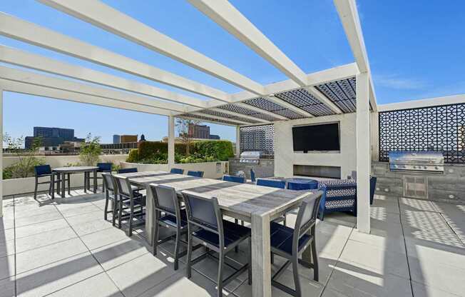 Outdoor grilling area with large dining table and two BBQ grills at Dominion Post Oak apartments in Houston, TX