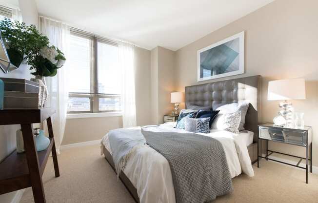 a bedroom with a large bed and two windows at The Acadia at Metropolitan Park, Arlington