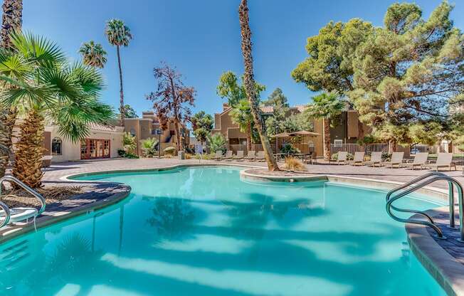 a swimming pool with palm trees and a building in the background at Pacific Harbors Sunrise Apartments, Las Vegas, NV, 89142