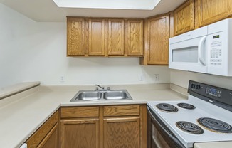 a kitchen with white appliances and wooden cabinets