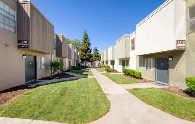A row of apartment buildings with the numbers 1320 and 1310 on the front.