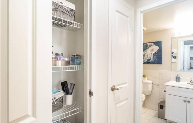 a small bathroom with white cabinets and a white door