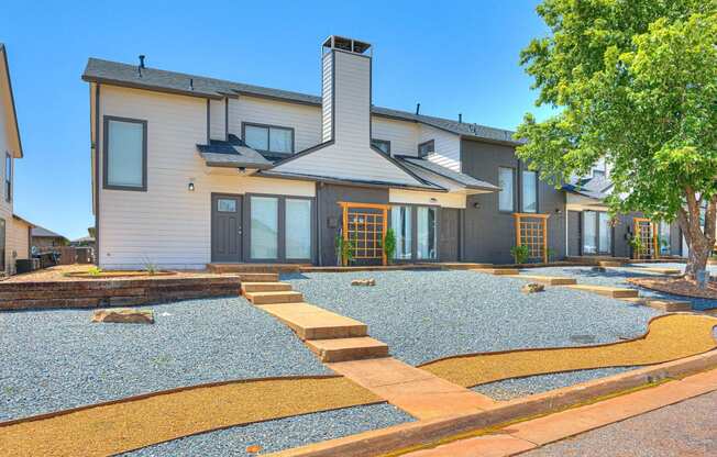 the front of a house with a gravel yard and a tree at Diamond Ridge Townhomes, Oklahoma City, OK 73114