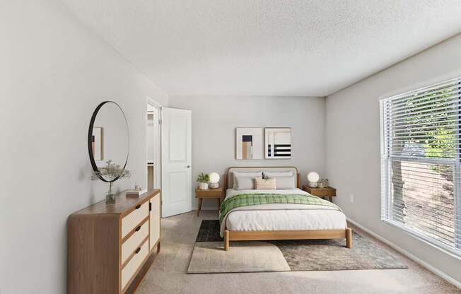 A bedroom with a bed, nightstand, and a mirror on the wall.