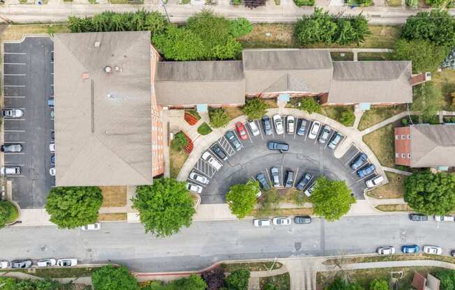 an aerial view of a neighborhood with cars parked in a parking lot