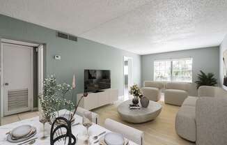 A living room with a dining table set for two and a television.