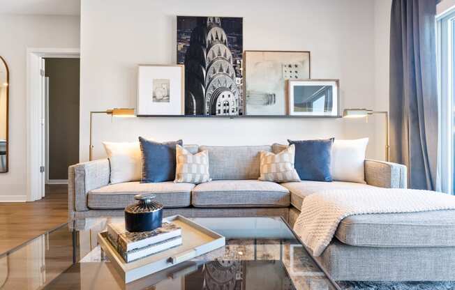 a living room with a gray couch and a glass coffee table