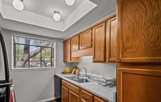 a kitchen with wooden cabinets and a sink and a window