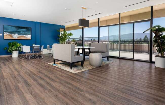 A modern office space with a wooden floor and a large window overlooking the beach.