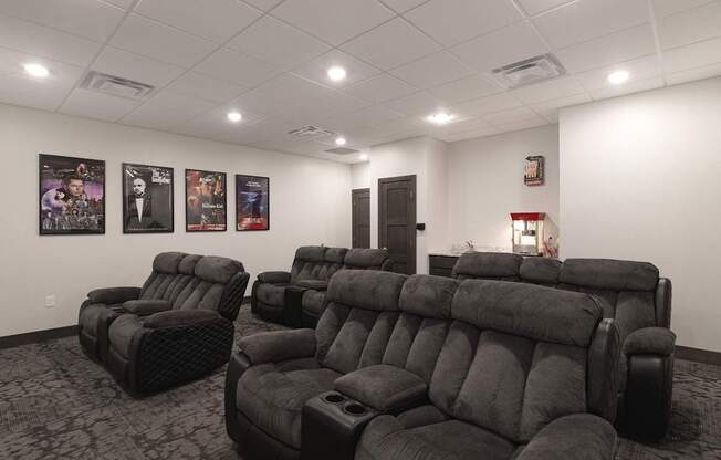 A row of black reclining chairs are arranged in a room.
