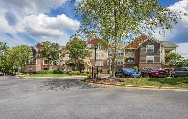 a street view of an apartment building with cars parked outside