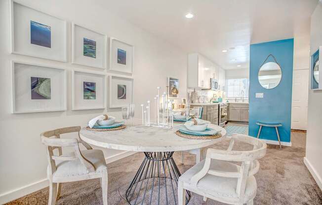 A dining room with a white table and chairs.