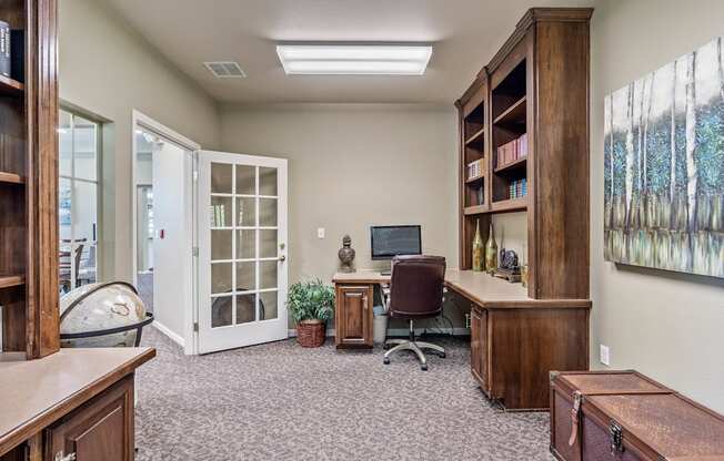 an office with a computer and a bookshelf