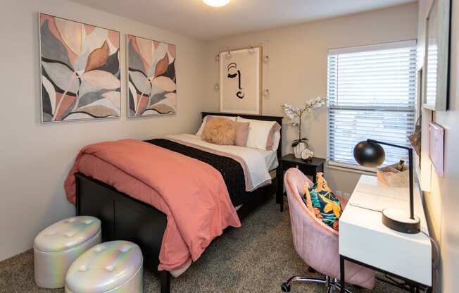 a bedroom with a bed and two paintings on the wall