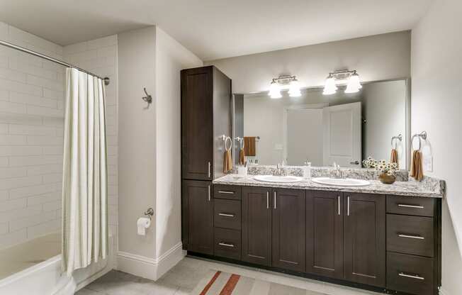 a bathroom with two sinks and a shower and a mirror