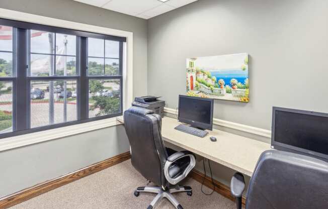 an office with a desk with a computer and a monitor