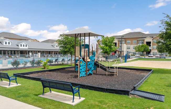 A playground with a slide and two benches.