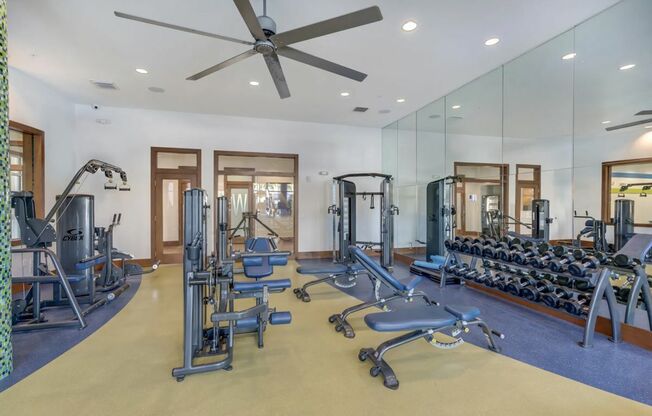 View of Fitness Center, Showing Exercise Machines, Free Weights, and Benches at The Marq Highland Park Apartments