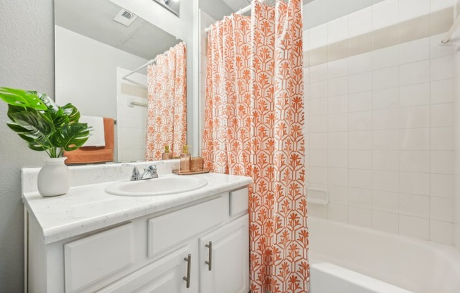 a bathroom with a sink and a tub and a shower curtain