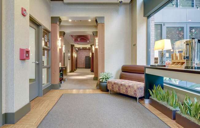 A hallway with a red fire alarm on the wall.