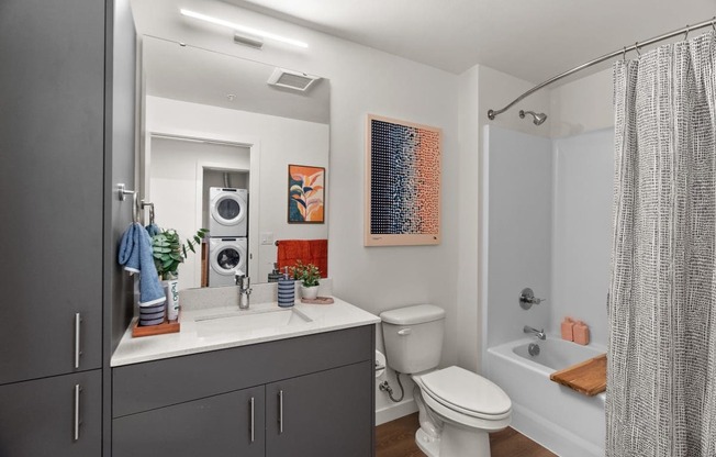 A bathroom with a toilet, sink, and shower.