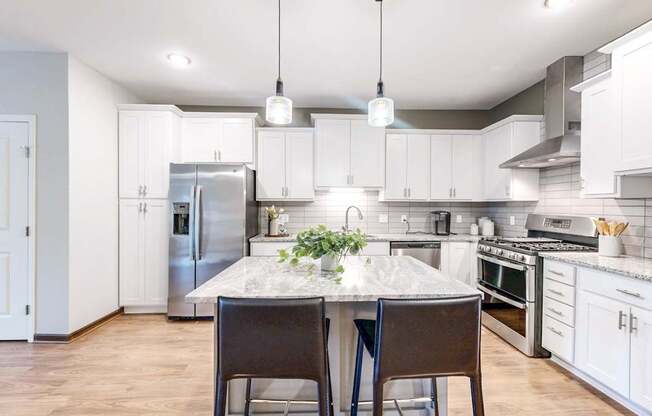 A kitchen with a table and chairs in the middle of it.