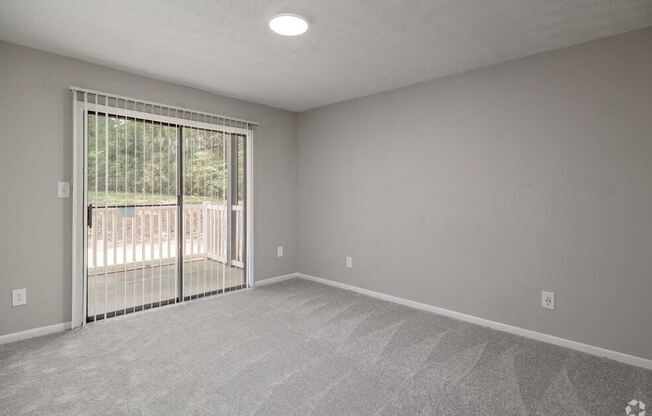 an empty living room with a sliding glass door to a balcony at Glen Hollow, Georgia 30034