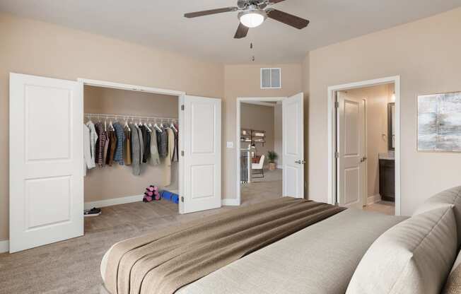 a bedroom with a closet and a bed and a ceiling fan