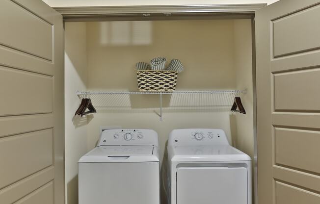 a white washer and dryer in a small laundry room