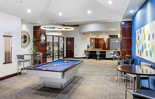 A billiard table is in the middle of a room with a pool table chair and a pool table table.