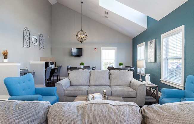 A living room with a grey couch and blue chairs.