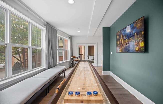 A room with a long table and a painting on the wall.