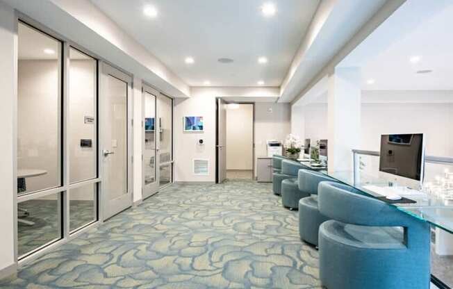 A long hallway with a blue carpet and glass doors.