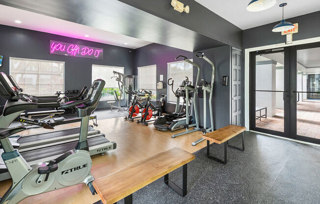 A gym with a variety of equipment including treadmills, weights, and exercise machines.
