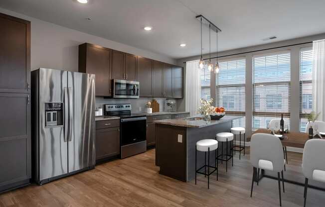 a kitchen and dining room with stainless steel appliances and a table with chairs