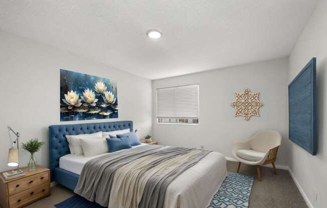 A bedroom with a blue headboard and a painting of flowers on the wall.