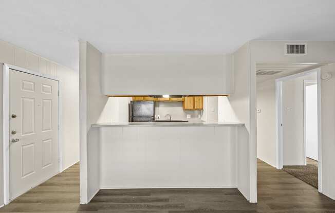 a white kitchen with a white counter top and a white door at Brookside Apartments, Hewitt, TX