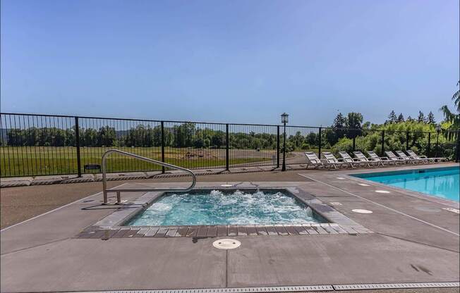 A pool with a hot tub in the middle of it at Riverplace Apartment Homes, Independence