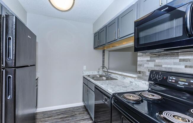 a stove top oven sitting inside of a kitchen with stainless steel appliances