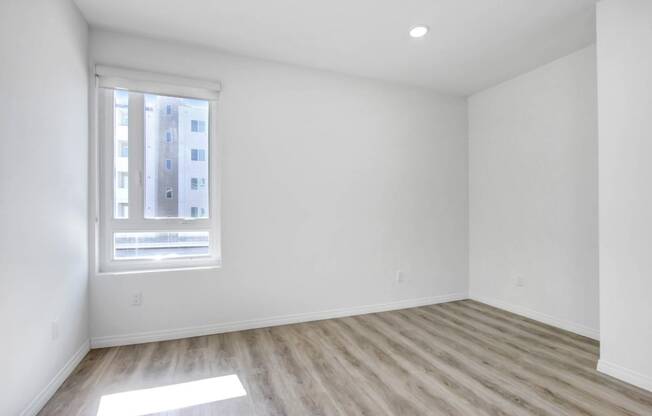 an empty room with white walls and a window