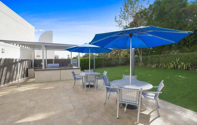 a patio with tables and chairs and umbrellas