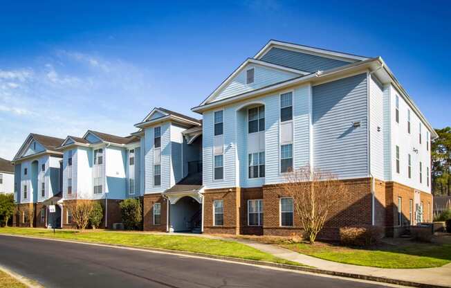 a row of blue and white apartment buildings on the side of a street