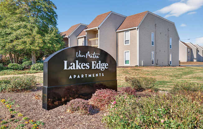 A sign for Lakes Edge Apartments is in front of a building.