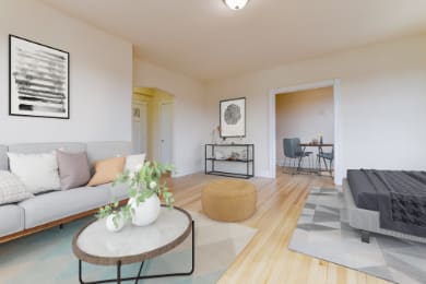 studio living area with sofa, coffee table, decorative shelving, and view of kitchen at the dahlia apartments in washington dc