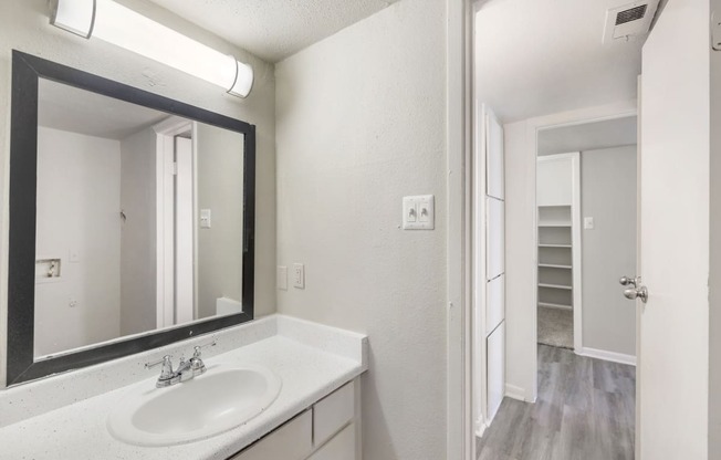 a bathroom with two sinks and a mirror and a closet