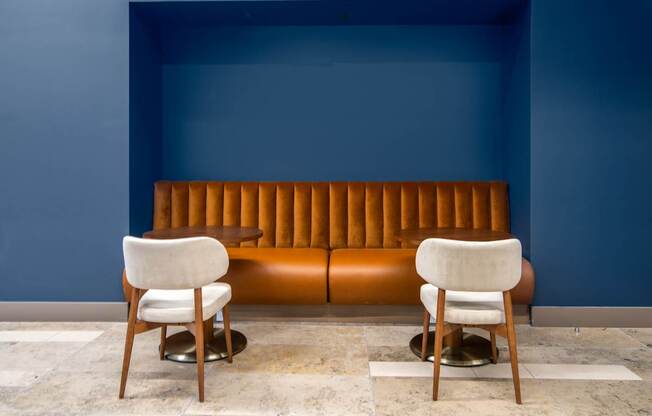 Two chairs are placed in front of a blue wall.