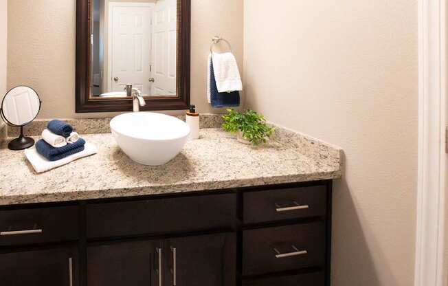 A bathroom with a white sink and a mirror.