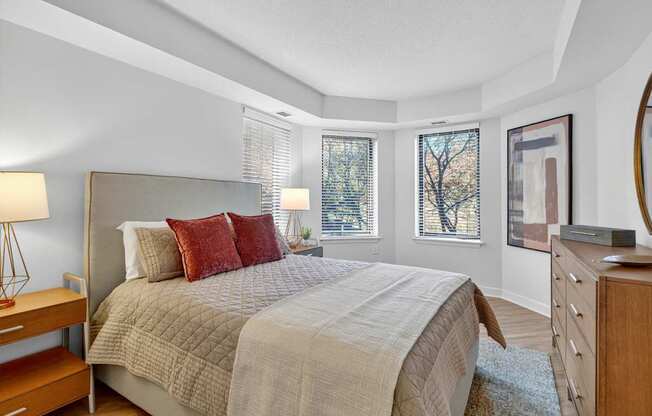 A bedroom with a large bed and a wooden dresser.