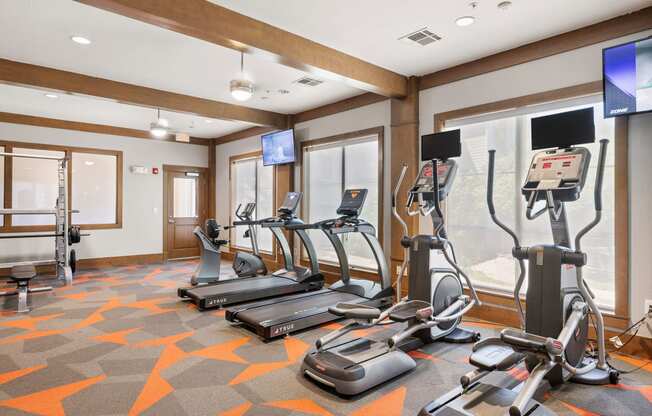 a gym with treadmills and other exercise equipment in a room