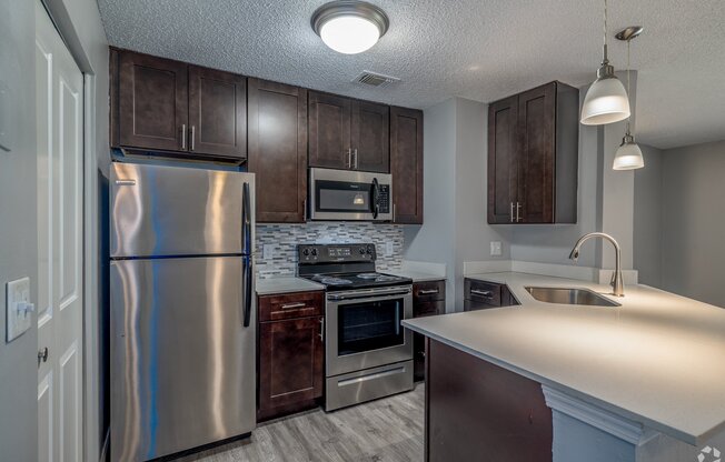 an updated kitchen with stainless steel appliances and wooden cabinets